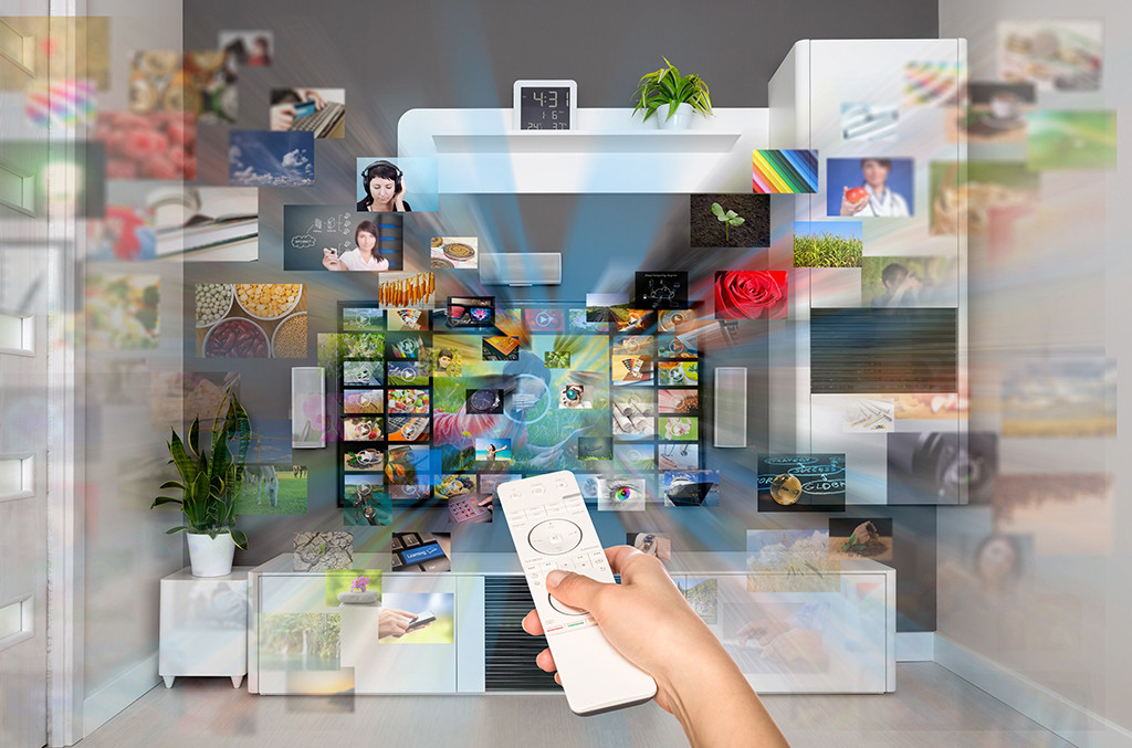 hand holding remote accessing every type of media showing how challenging it is for media placement specialists to try and reach their audience