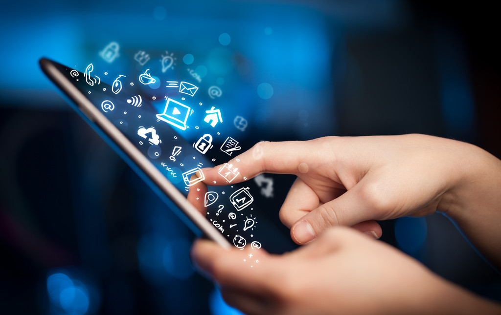 person touching an iPad with various social media icons