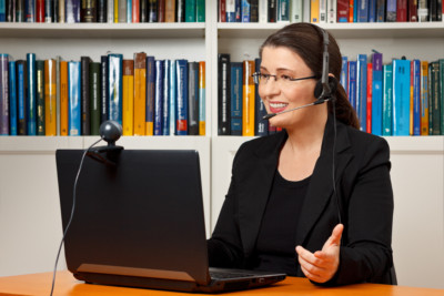 woman-headset photo of woman teaching through computer with headset